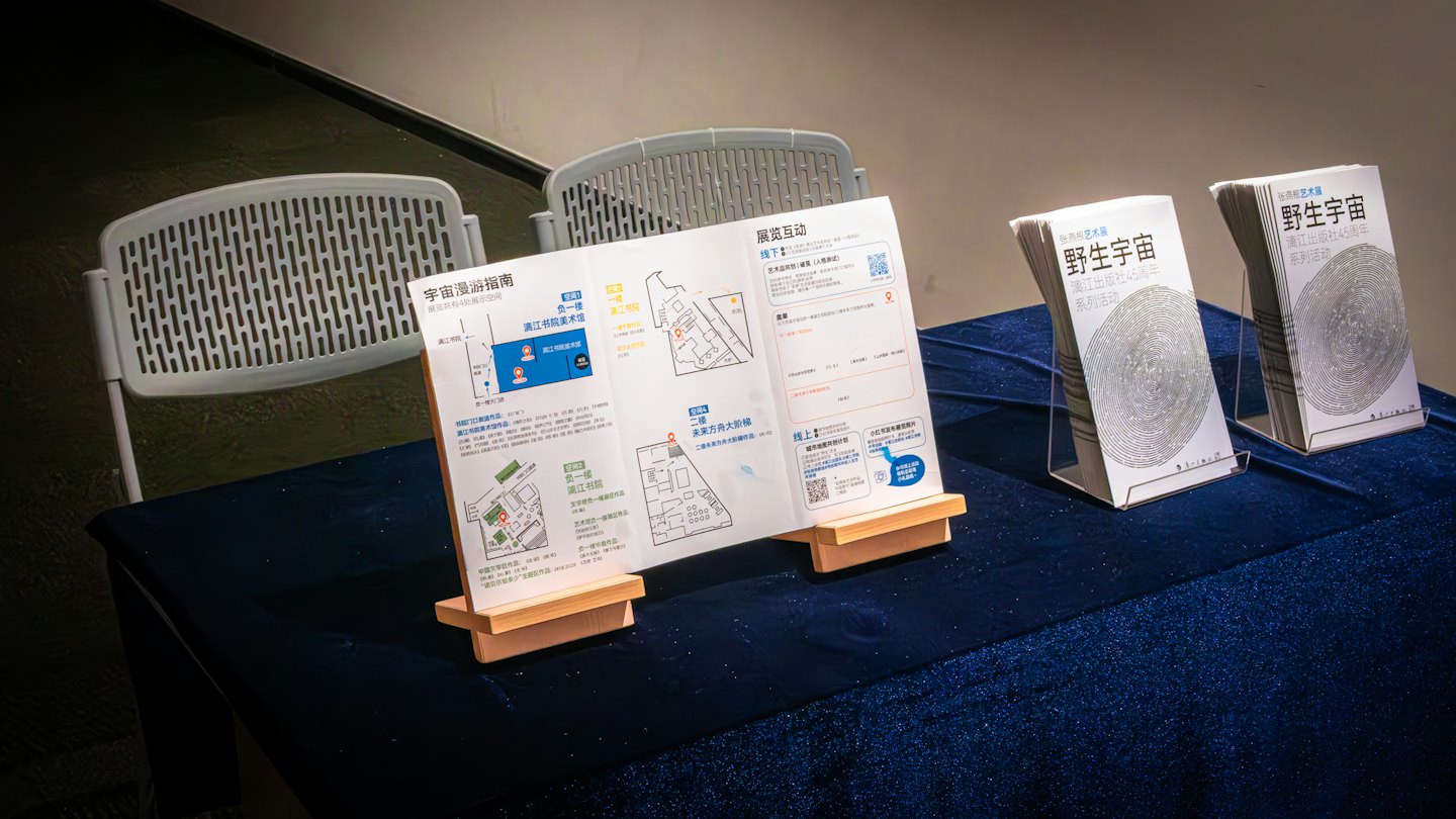 Brochures et livrets sur des présentoirs disposés sur une table bleue.